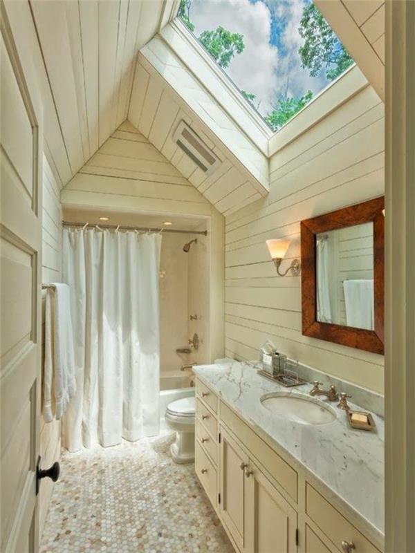 kokonuojantis vonios kambarys, baltos medienos sienų apmušalai, didelis stogo langas, veidrodis įrėmintas iš pjaustytos medienos