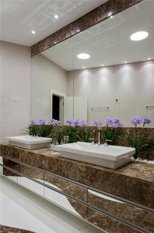 kokonuojantis vonios kambarys, stačiakampiai balti praustuvai, dekoratyvūs balti akmenukai