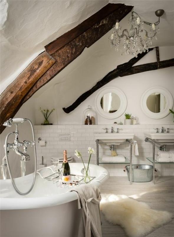 eleganten deželni dekor za kopalnico, samostoječa kad, izpostavljeni tramovi, bele ploščice, okrogla ogledala, konzolni umivalnik, krznena preproga