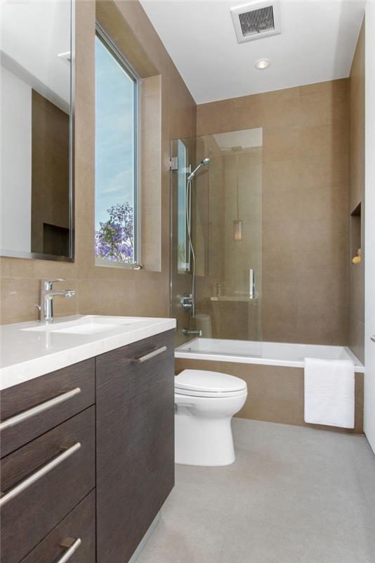 model majhne kopalnice s kadjo z bež stenami in sivim podom z belim stropom, toaletna enota z belim pultom in temnimi vrati