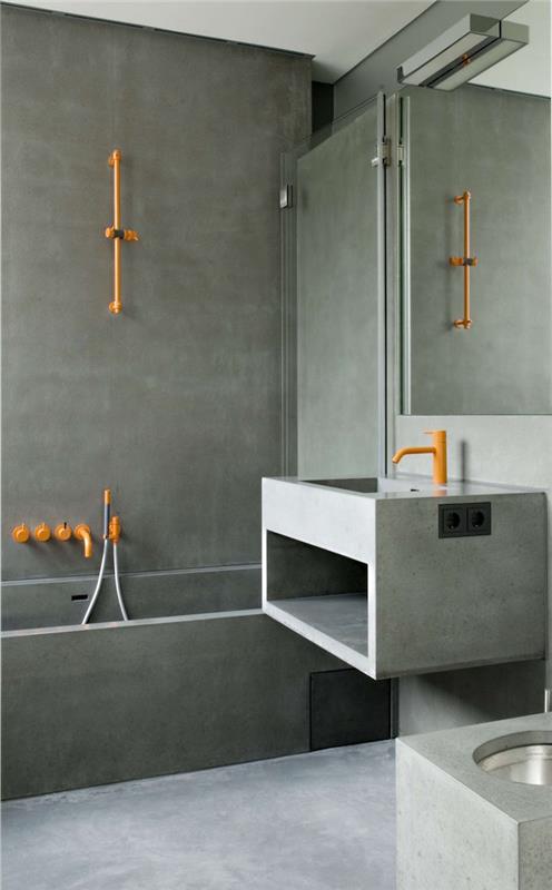 Modern banyo duvarında mumlu betondan duşakabin ve çimento lavabolu ve turuncu metal sıhhi tesisatlı tasarım