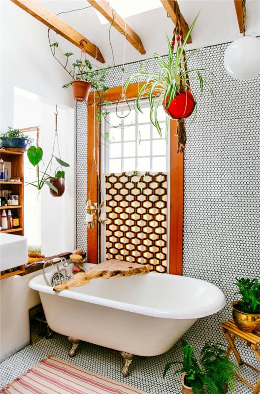 senovinė balta vonia su bronzos spalvos metalinėmis kojelėmis, šviesiai rudos medinės sijos ant lubų, bohemiškos vonios stilius, kambariniai augalai, žalias vonios kambarys