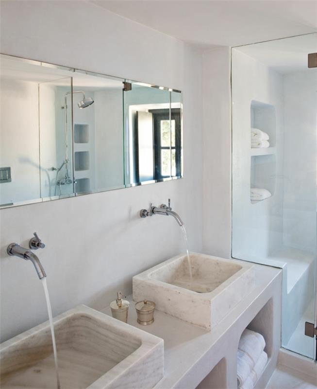 Grška kopalnica, marmorni umivalnik, tuš kabina, bele stene, veliko ogledalo, bele brisače