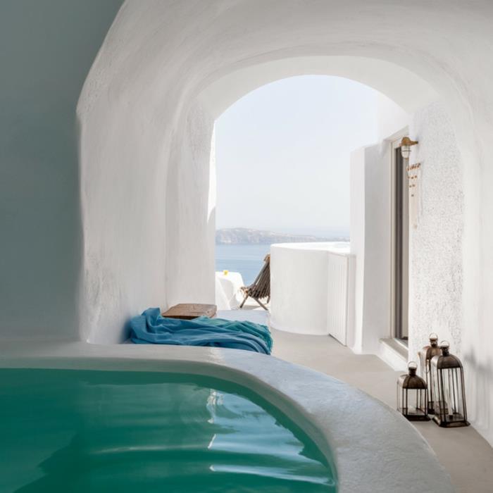 Grška dekoracija, pogled na morje, bele stene, lok, modra brisača, lesena klop