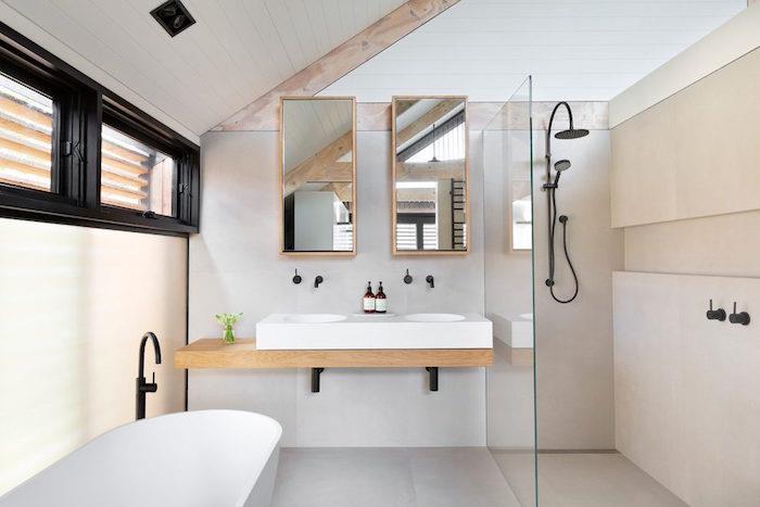 Majhna mansardna kopalnica pod streho z minimalističnim skandinavskim dizajnom deco z lesom in belimi stenami