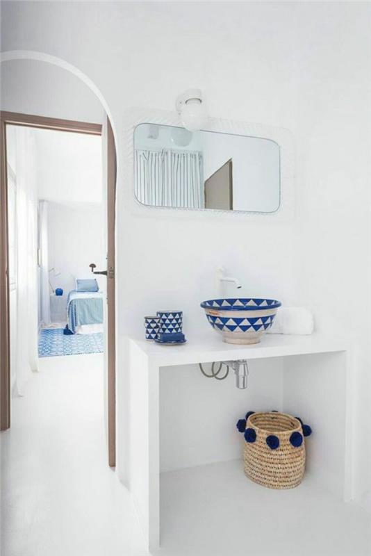 Kopalnica 5m2, dekor kopalnice Zen, bela miza, košara za shranjevanje tkane slame z mornarsko modrimi pomponi naokrog, bele ploščice