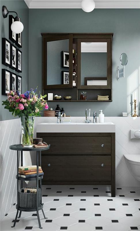 mažas vonios kambarys su taupe spalvos baldais ir miniatiūriniais paveikslais su juodais rėmeliais