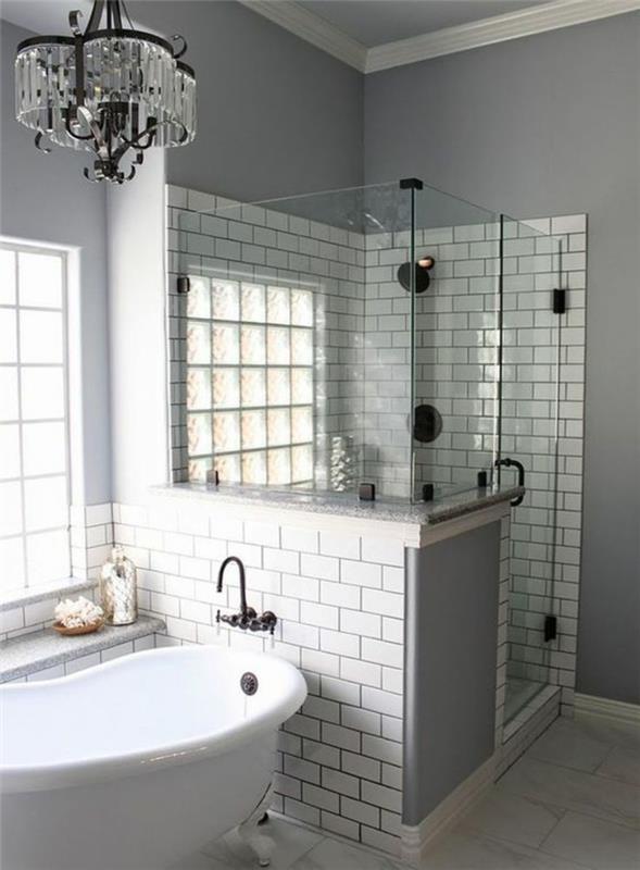 mažas vonios kambarys su kampiniu itališku dušu iš pilkų plytų su metaline ir krištolo liustra