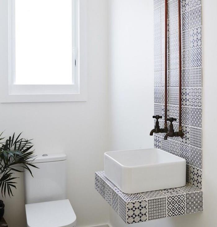 beyaz lavabo ve siyah beyaz çizgili fayans, wc ve beyaz duvarlar ile küçük tasarımcı banyo