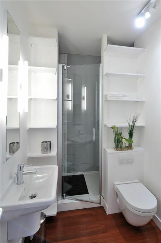 mažas vonios kambarys labai funkcionali erdvė su baltomis lentynomis per visą vonios aukštį