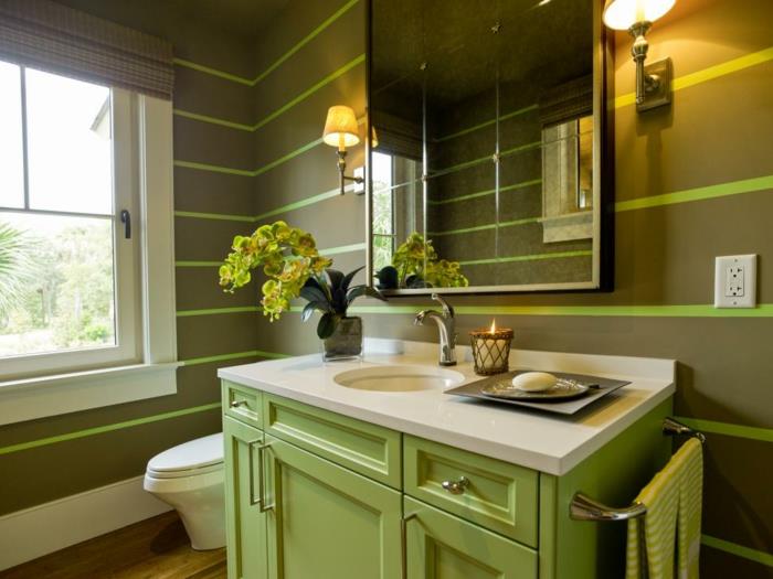 žalia tualeto apdaila, apvalus po kriaukle, žalia praustuvo spintelė, du žvakidės, veidrodis, baltas langas