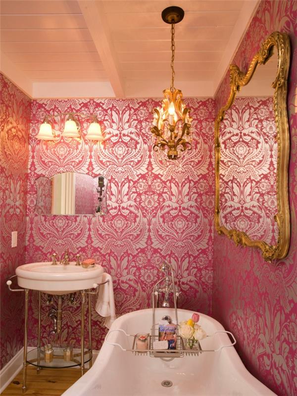 beyaz küvet, barok pembe duvar kağıdı, barok çerçeve ayna ve asılı ışık, yuvarlak lavabo; küçük dekoratif ayna