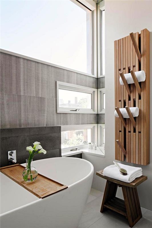 Zen kopalniški dekor s samostoječo kadjo, majhno kmečko leseno stransko mizo in lesenim držalom za stenske brisače