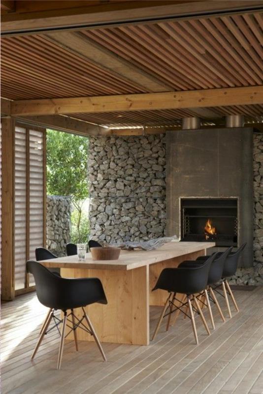 svetainė-su-akmens-sienų apdaila-pilka-ir-stalas-šviesios medienos