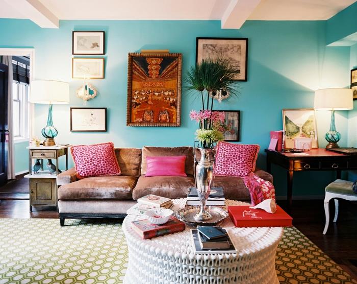 geometrijska preproga v bledih barvah, roza blazine, bež kavč, leseno pohištvo v baročnem slogu