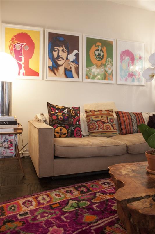 taupe kavč, pisana preproga, pristna lesena miza, večbarvne blazine, slike pop arta