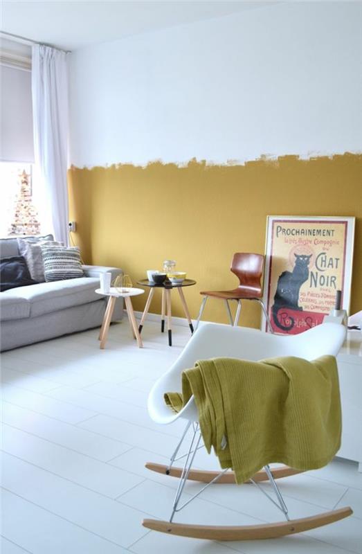 İskandinav tasarımına sahip bir oturma odası ve duvarın yarısında koyu sarı boya ile enerji verilen beyaz bir zemin