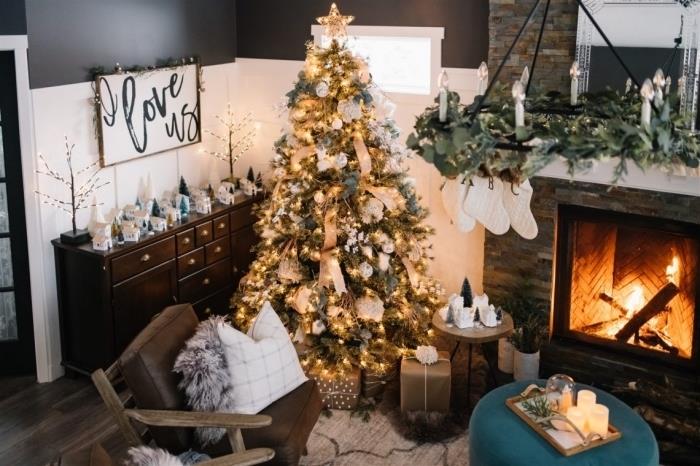 Noel için dekore edilmiş şömineli bir oturma odasında rahat bir atmosfer, altın ve gri renklerde şık bir ağacın nasıl dekore edileceğine dair fikir