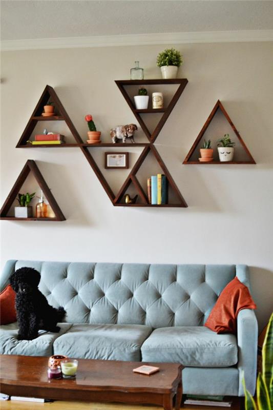 oturma odası-mavi-kanepe-ve-duvar-dekorasyonu-üçgen şeklinde raflı
