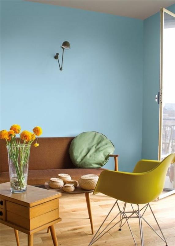svetainė su šviesiai mėlynomis sienomis, geltona plastikinė kėdė, šviesaus medžio parketas, svetainės baldai