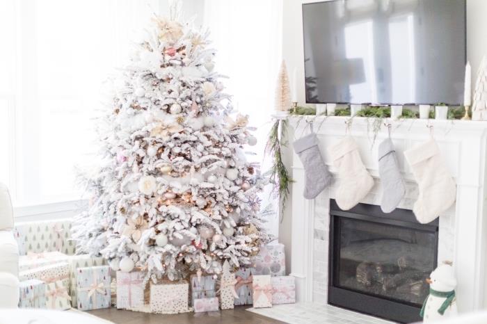 beyaz ve metalik bir şekilde dekore edilmiş büyük bir Noel ağacı ile Noel için beyaz bir oturma odasında koza dekorasyonu