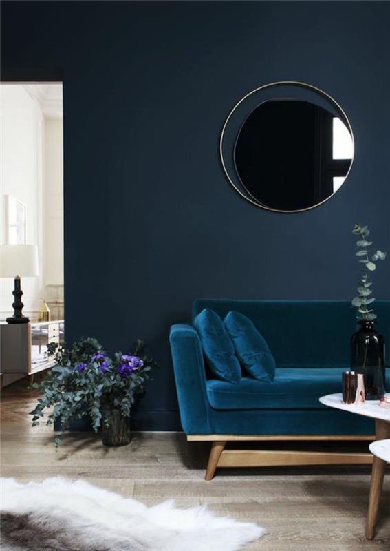 povas mėlyna aksominė sofa su benzino mėlyna sienų spalva, jauki madinga dekoro idėja svetainei