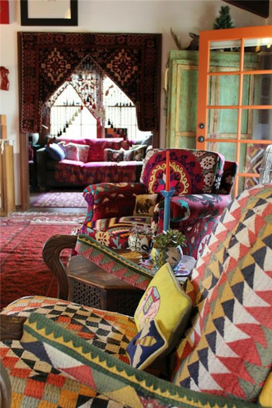 bohemiškas dekoras, raudonas kilimas, etninio rašto fotelis, dekoratyvinės pagalvėlės, žvakės