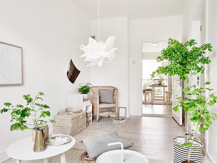 urejanje bele in lesene dekoracije dnevne sobe, svetel parket, košare in stol iz ratana, bela viseča svetilka, bela mizica, zelene rastline