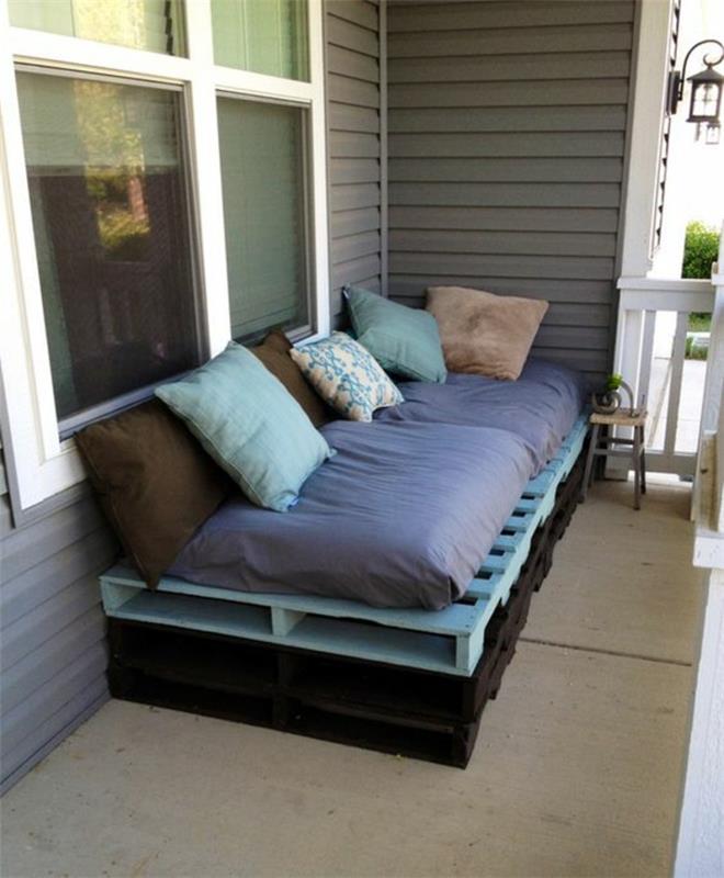 padėklų sofa, nudažyta juodos ir pastelinės mėlynos spalvos, čiužinys indigo mėlynos spalvos, pagalvėlės rudos, mėtų žalios ir smėlio spalvos, sodo baldai padėkle
