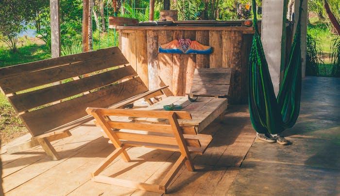 kako sami narediti vrtno pohištvo iz surovega lesa na leseni terasi, klopi, stoli in miza surov les, gugalnice v viseči mreži v boemskem stilu