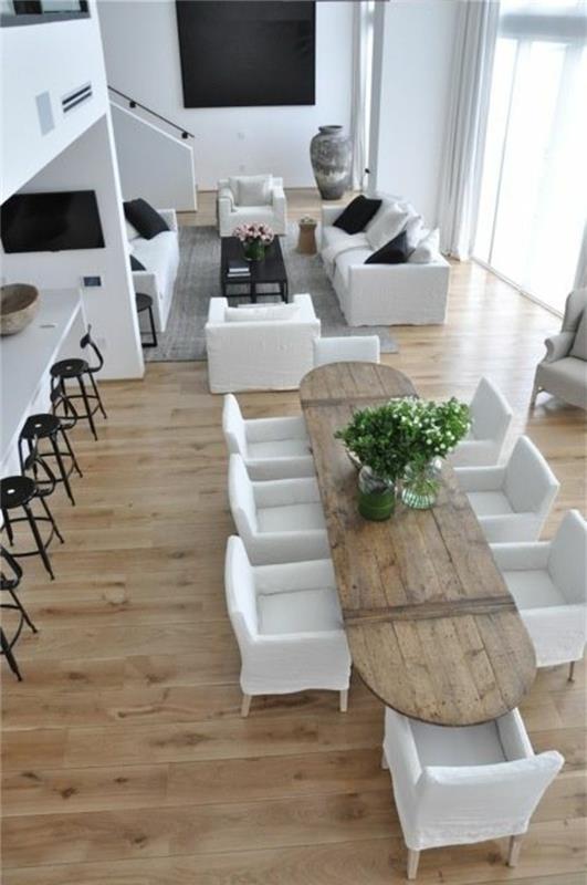 dolgi-bivalni prostor-svetlo-leseno-tla-beli-stoli-dolga miza-v-svetlem-lesu-beli stoli