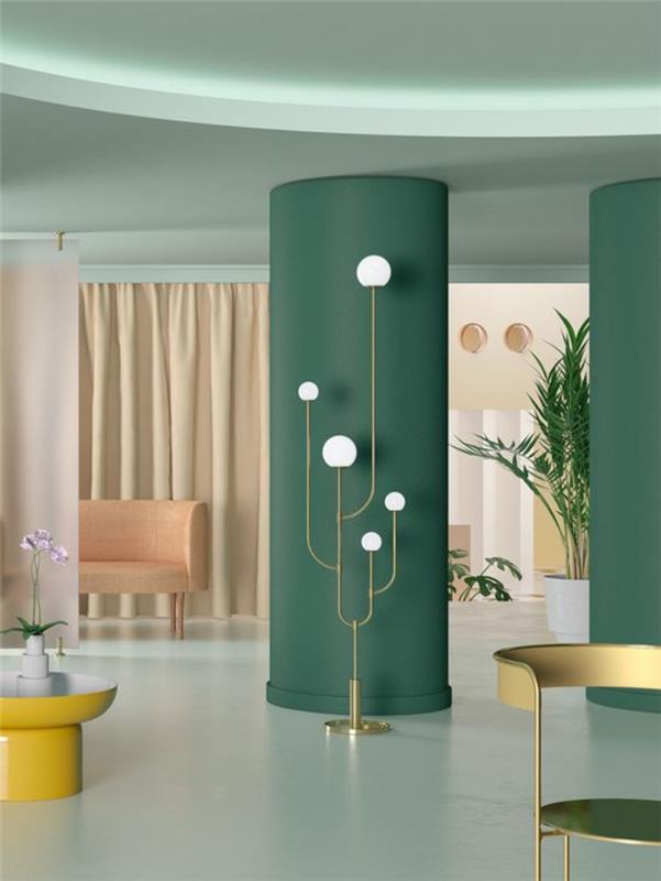 gyvenamojo kambario miegamojo atskyrimas su ryškių spalvų kolonomis, žalia, ovalo formos kolonos, baltos plytelės, rožinė sofa, auksinis metalinis fotelis, apvalus kavos staliukas geltonos spalvos