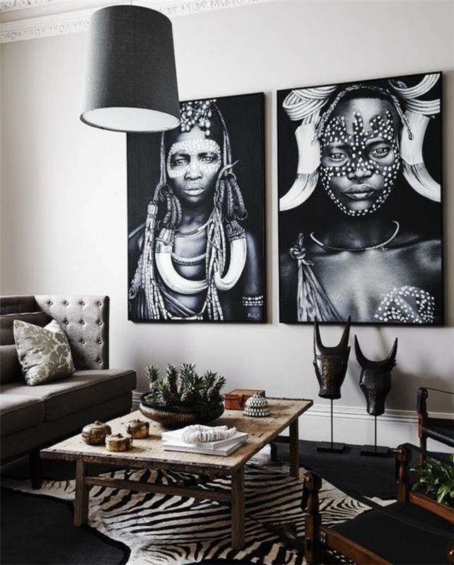 Siyah ve beyazı zarif bir şekilde birleştiren Afrika tarzı şık etnik oturma odası, etnik motiflerle basılmış posterlerin olduğu bir duvar galerisi