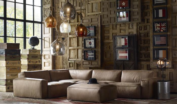 dominuojanti bistre spalva šioje palėpės svetainėje, sudaryta iš šviesiai rudos odos sofos ir medinių sienų