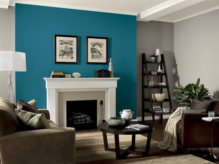 moderni svetainė rudos, taupe ir povo mėlynos spalvos atspalviais, mėlynos sienos dalis, ribojanti tradicinį židinį