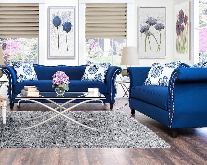 model polnočno modrega kavča v dnevni sobi z okvirjem cvetličnega vzorca deco, mehka siva preproga na parketu v dnevni sobi