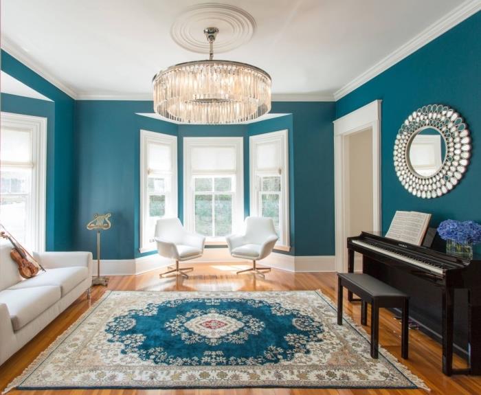 İç mekanın renklerini alan şık bir halı ile zarif ve klasik bir görünüme sahip tavus kuşu mavisi ve beyaz bir oturma odası için deco ilhamı