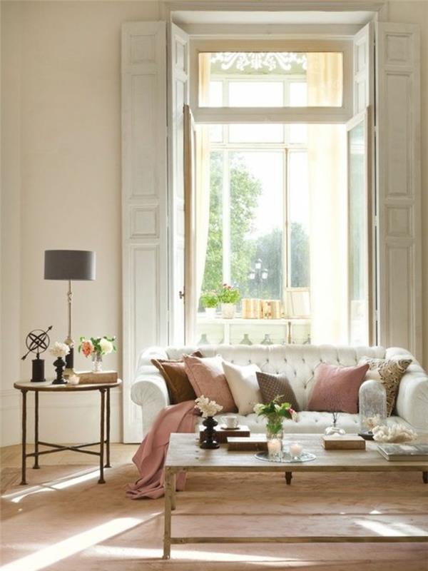 svetainė-aukštos lubos-svetainė-baldai-smėlio spalvos-dekoratyvinės pagalvėlės-sofa-oda-balta-papildanti spalva-smėlio spalvos-dažai-svetainė