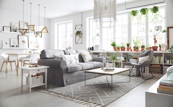 İskandinav halısı ve gri kanepe, beyaz yemek alanı, beyaz depolama rafı, minimalist ahşap ve metal sehpa, yeşil bitkiler dekoru ile gri ve beyaz oturma odasına açık yemek odası
