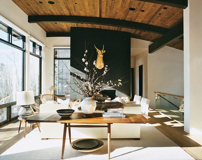 jedilnica za dnevno sobo z oblikovalskim dekorjem in črnimi izpostavljenimi tramovi z lesenim stropom v zlati jelenovi glavi