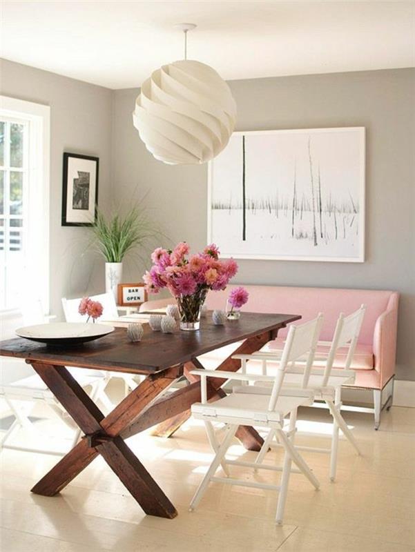 „Arredamento sala da pranzo con un tavolo di legno“ ir „sedie bianche“, akcento spalva ir „divano rosa“