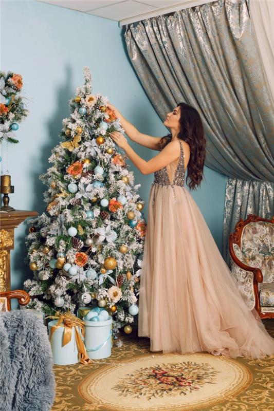 Božično drevo, okrašeno s svetlo modrimi, zlatimi in belimi božičnimi kroglicami ter okrasnimi umetnimi cvetovi