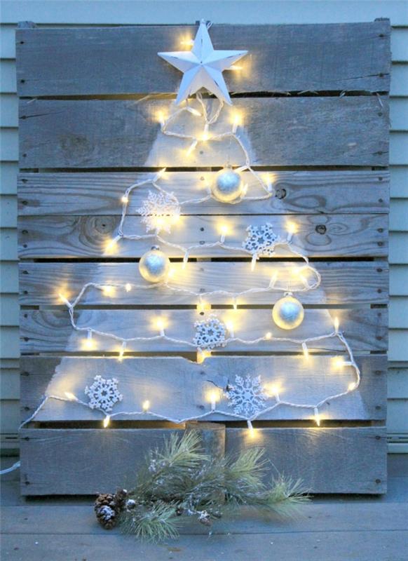 stebuklinga Kalėdų puošmena, pagaminta ant balto medinio padėklo, baltų lempučių girlianda, pušies šakelė
