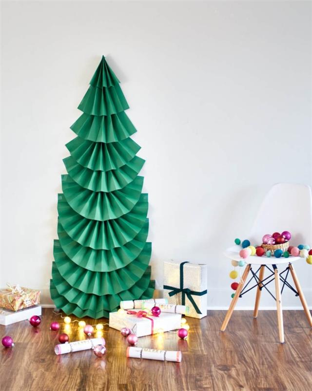 Bir yelpazede katlanmış ve duvara sabitlenmiş kağıt yapraklardan yapılmış büyük kağıt Noel ağacı