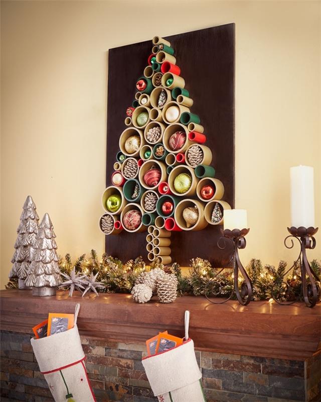 Altın, kırmızı ve yeşil boyalı, geri kazanılmış pvc tüplerden yapılmış, geleneksel bir şömineyi aşan orijinal bir duvar çerçevesi Noel ağacı