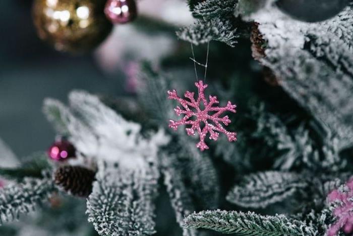 Kalėdų tapetų pavyzdys, snieguota eglė su blizgančiais purpuriniais sniego kolbos ornamentais ir Kalėdų rutuliai