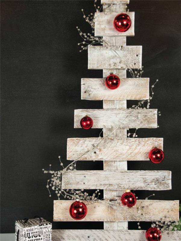 yumuşak İskandinav tarzı dekor, Noel ağacına dönüştürülmüş palet, kırmızı Noel topları ve kuru beyaz çiçekler
