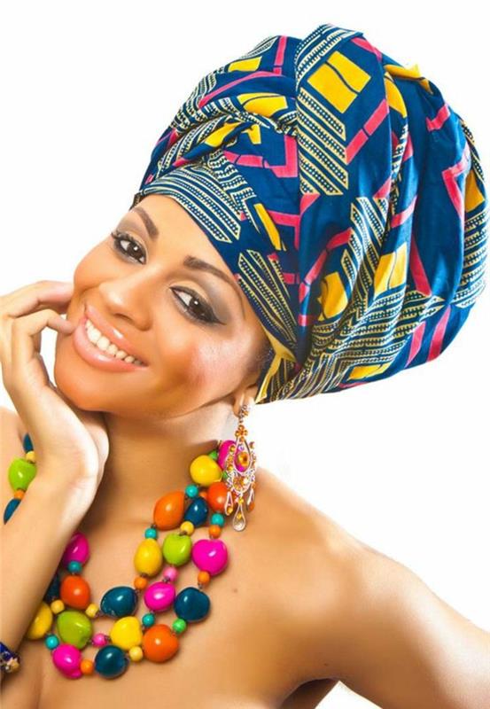 Ragazza sorridente, tessuti africani colorati, collana con pietre di diverso colore, testa içinde sciarpa