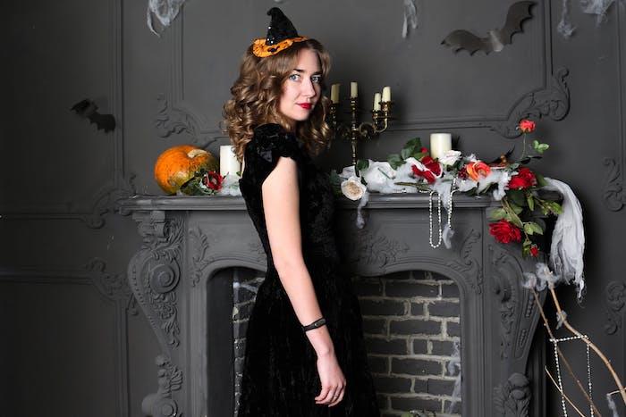 sihirbaz kostümü, siyah elbiseli cadı stili ve siyah ve turuncu orijinal cadı şapkası, cadılar bayramı şömine dekoru