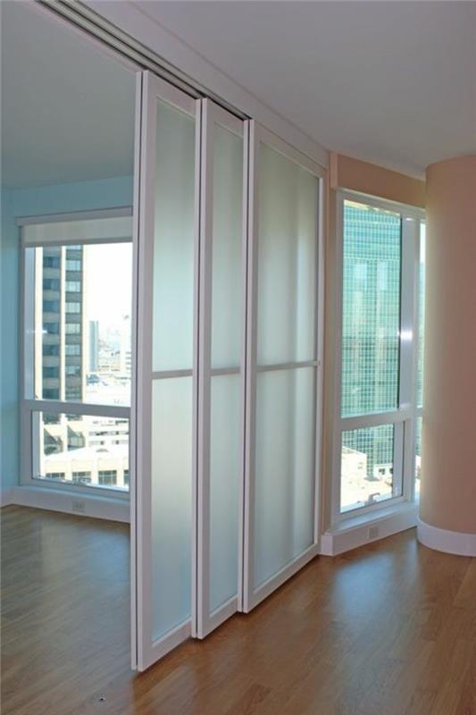 balto metalo kambario pertvara, trys stumdomos durys, šviesi erdvė, lašišos spalvos kolona, ​​šviesiai rudos PVC parketo grindys